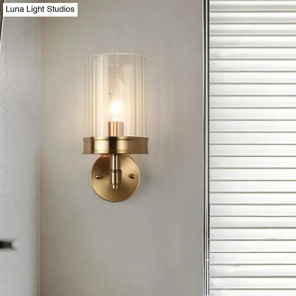 Modern gold finish wall light with brass finish and clear textured glass shade suitable for bedroom sconce with warm color temperature