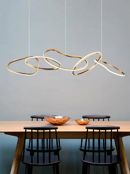 Modern gold flowing ring led decorbites elegant chandelier with interlocking circular rings above dining table