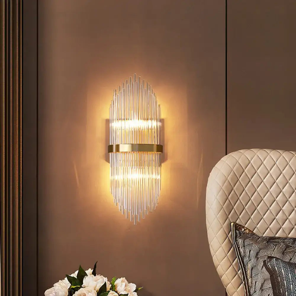 Modern gold flute shaped wall sconce featuring clear crystal rods and a metal frame ideal for bedroom lighting