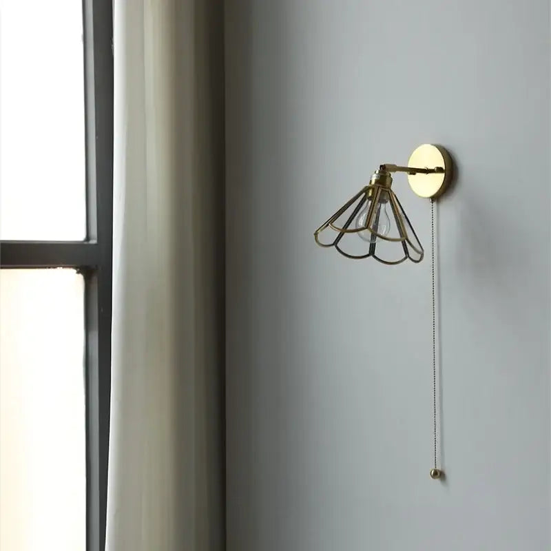 Gold-toned wall sconce with a fan-shaped metal cage and pull chain ideal for decorbites led wall sconce bedroom lighting
