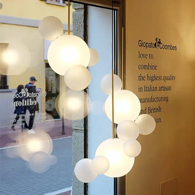 Modern gold pendant light with frosted glass ball globes in a cascading cluster for dining room lighting