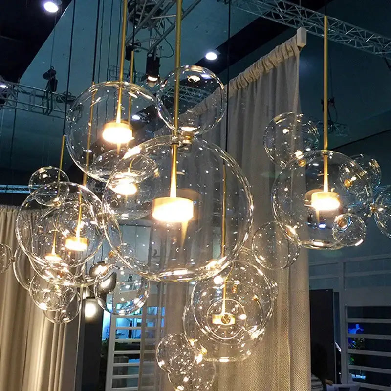 Modern gold pendant light with frosted glass ball spheres and warm bulbs for elegant dining room lighting