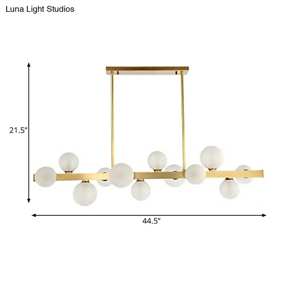 Modern gold frosted glass pendant light with chain cord length and globe bulbs arranged in a linear pattern for dining room island
