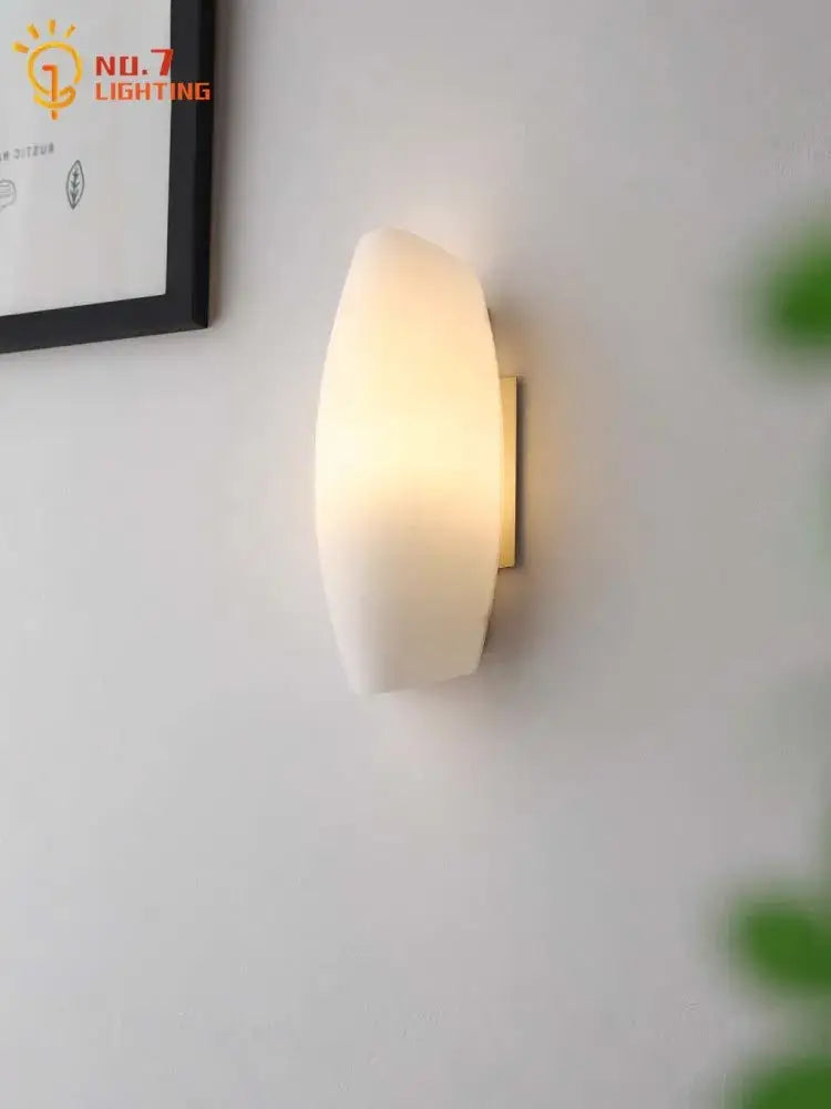 Modern gold frosted glass led wall lamp with warm-toned glass and sleek brass backplate for bedroom lighting
