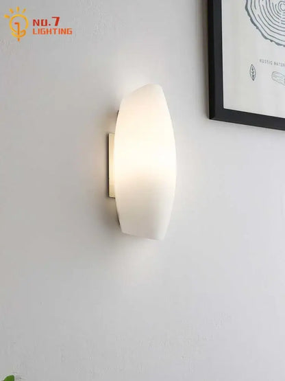 Modern white frosted glass led wall lamp with a sleek curved design and metallic mounting bracket for bedroom lighting