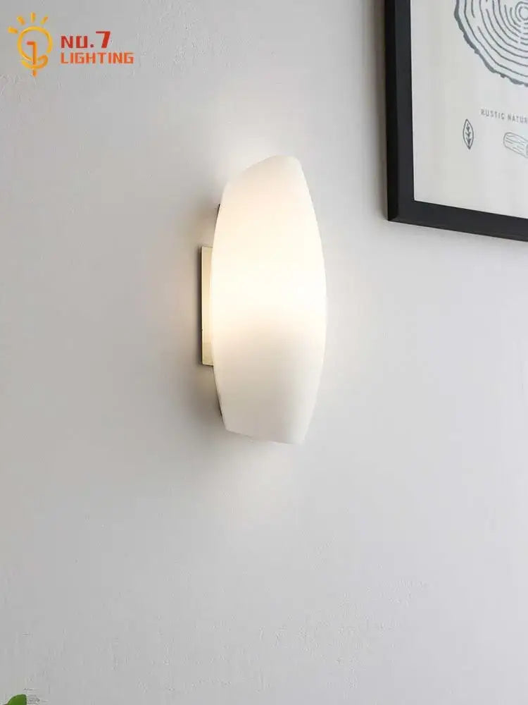 Modern white frosted glass led wall lamp with a sleek curved design and metallic mounting bracket for bedroom lighting