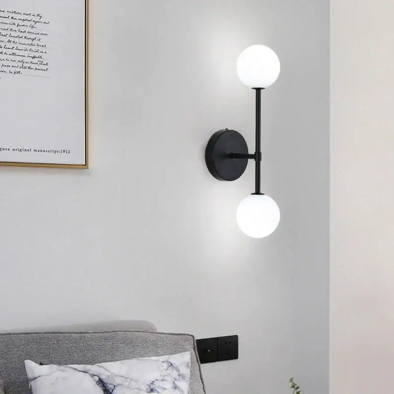 Modern black minimalist led wall sconce with two frosted glass globe shades for bedroom lighting