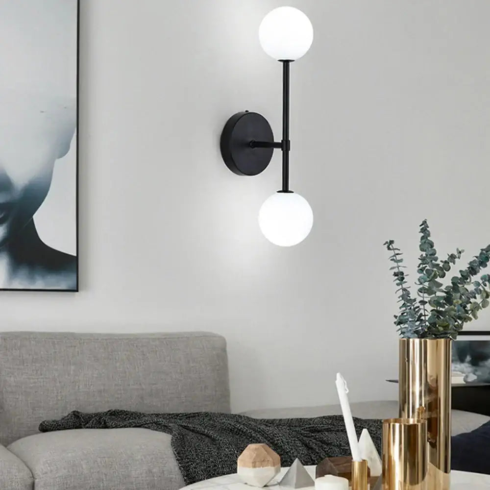 Black led wall sconce with two frosted glass globes for modern bedroom lighting