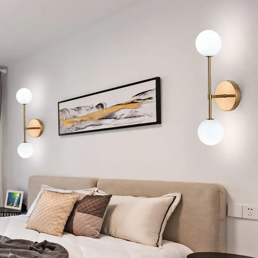 Modern gold frosted glass led wall sconce with two spherical white glass shades for bedroom lighting