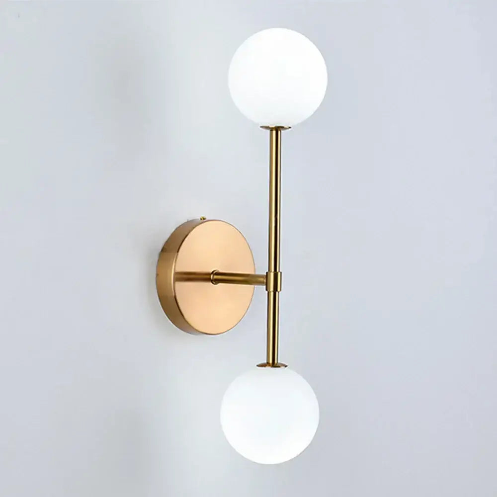 Modern gold led wall sconce with frosted glass globe shades ideal for bedroom lighting