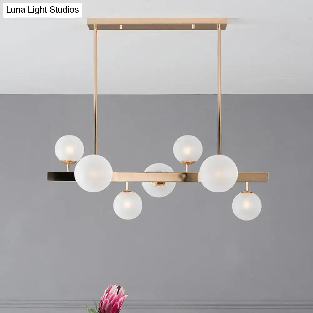 Modern gold frosted glass round island pendant with frosted glass globe bulbs in a linear kitchen light design