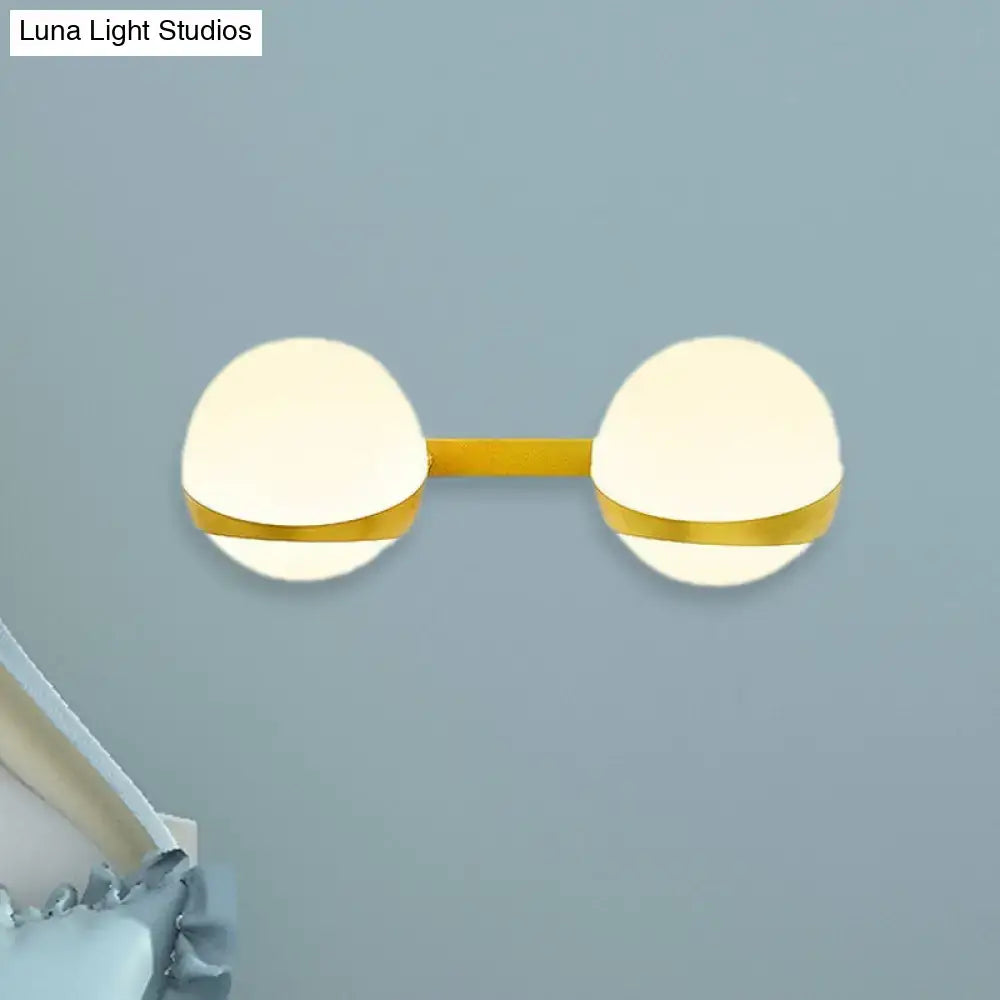Modern gold frosted glass wall sconce with two glowing spherical shades and direct wired design for bedroom lighting