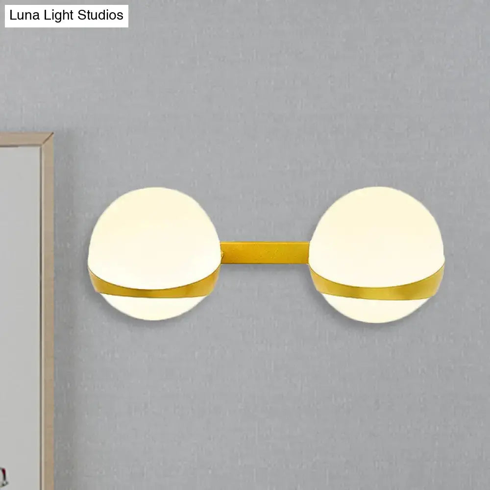 Modern gold frosted glass wall sconce with two spheres on a sleek bar for bedroom direct wired lighting