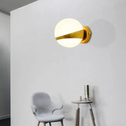 Modern gold frosted glass wall sconce with spherical globe and sleek direct wired design for bedroom lighting