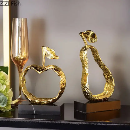 Modern gold fruit shaped metal crafts featuring textured apple and pear decorbites fruit shaped accents on marble bases