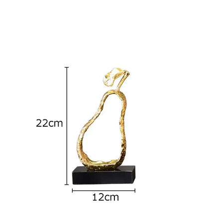 A sleek gold-toned pear shaped metal craft with textured surface and leafy top on black base for modern decorbites fruit shaped decor