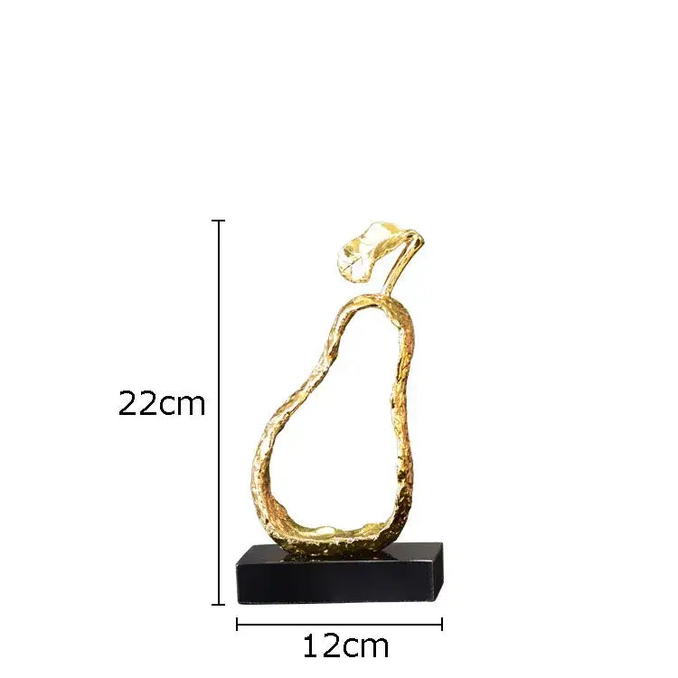 A sleek gold-toned pear shaped metal craft with textured surface and leafy top on black base for modern decorbites fruit shaped decor