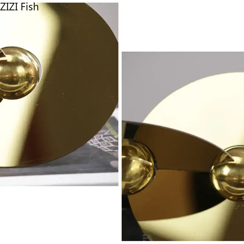 Gold-colored sleek metallic fish-shaped lamp with polished brass finish featured as geometric circle sculpture ornament