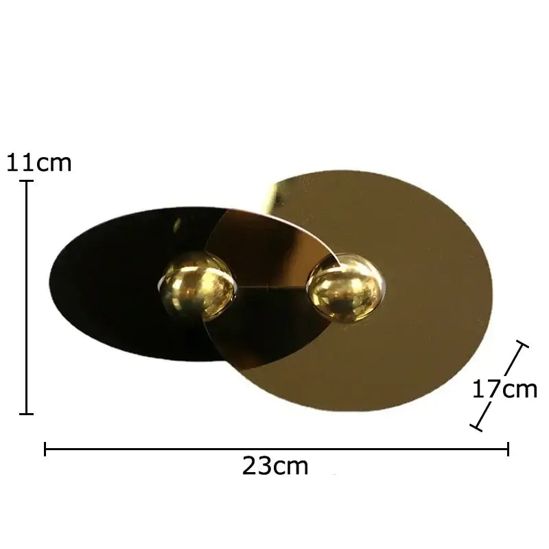 Modern double-sided wall sconce with sleek black and gold metallic finish featuring geometric circle sculpture design