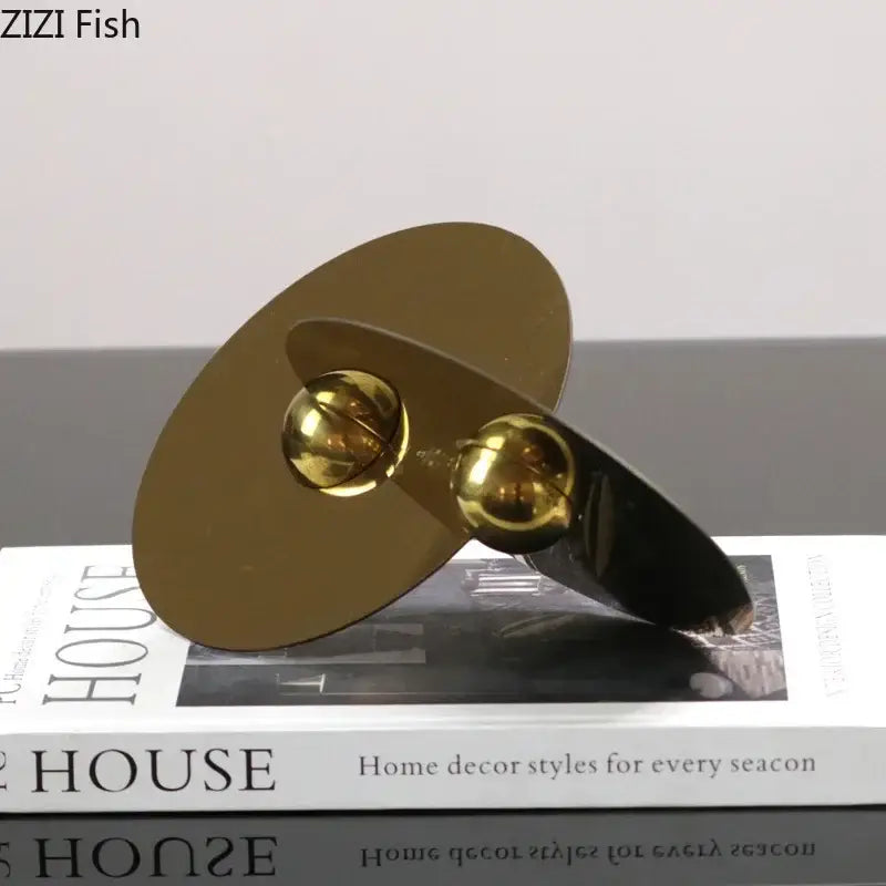 Modern gold geometric circle sculpture with two polished metallic discs and reflective spheres for minimalist decor
