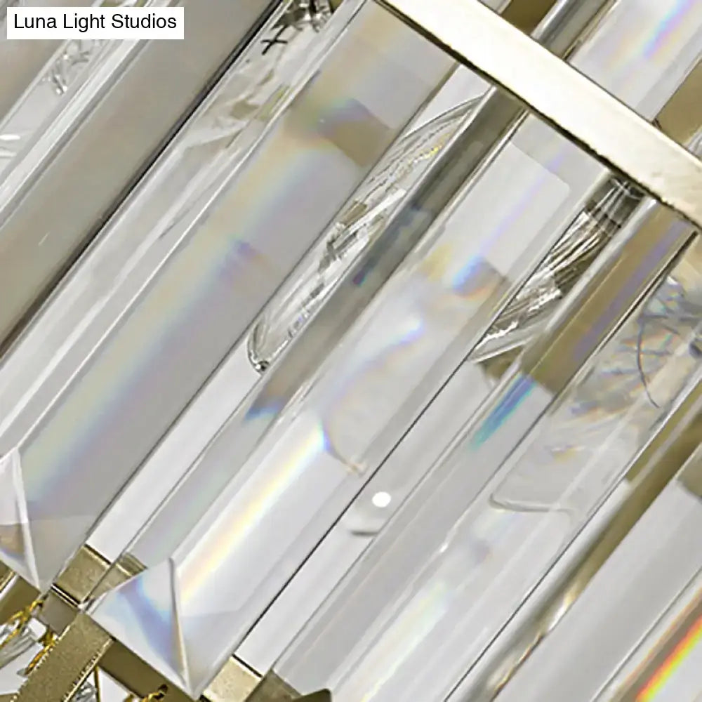 Modern gold geometric wall lamp featuring clear crystal prisms in polished gold-toned metal sconce fixture