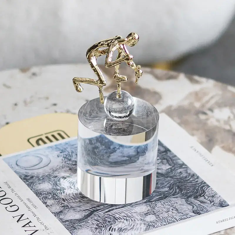 Modern gold geometric crystal sculpture featuring a gold-toned worker figurine on a clear acrylic pedestal decorbites geometric crystal decorbites geometric crystal sculpture