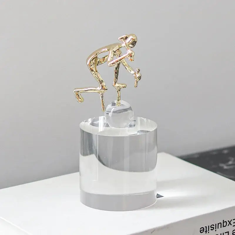 Modern gold geometric crystal sculpture featuring a gold worker figurine atop a clear acrylic base by decorbites