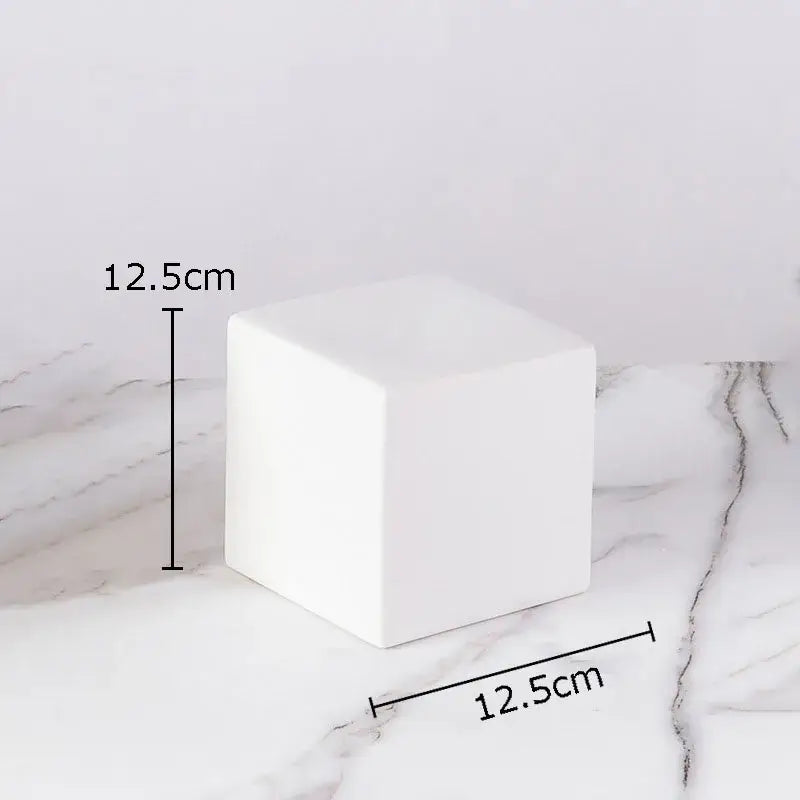A sleek solid white ceramic cube round statue with smooth edges and minimalist design for modern living room decor