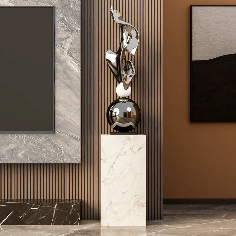 Modern gold geometric electroplating art sculpture with shiny chrome design and glossy black base on white marble pedestal decorbites geometric electroplating art