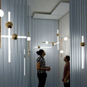 Modern gold geometric line frame pendant lights with sleek metal arms and glass globes for dining room lighting