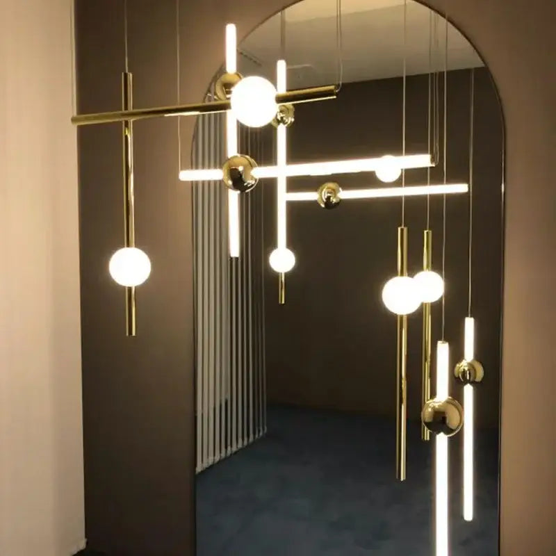 Modern gold geometric line frame pendant lights with spherical and cylindrical glass globes for dining room