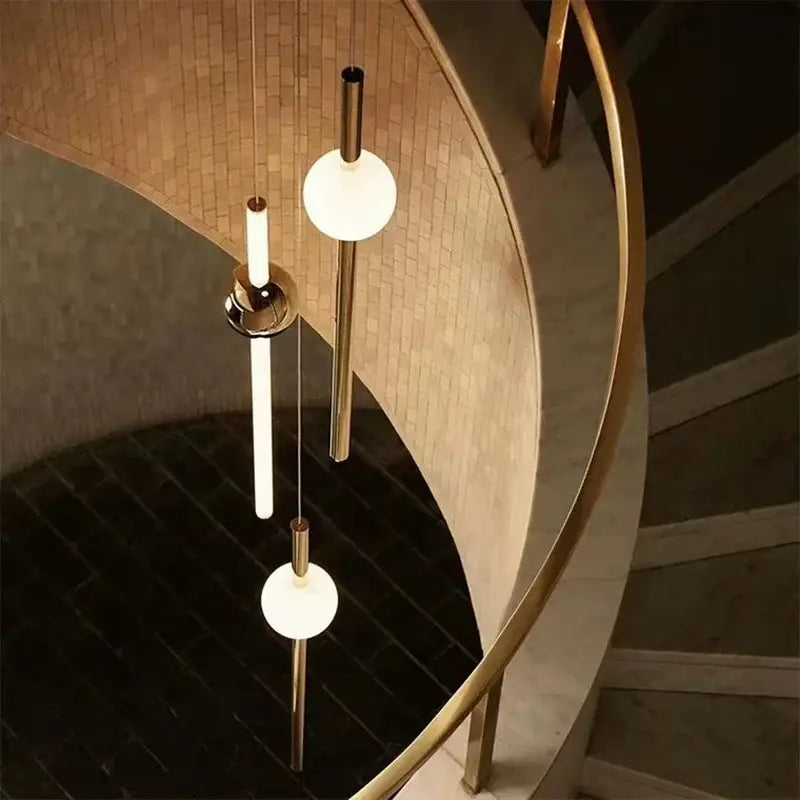 Modern gold geometric line frame pendant lights featuring sleek metal rods and frosted glass globes for dining rooms