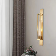Modern gold wall mount lamp with rectangular geometric metal frame and clear ribbed glass shade for bedroom use
