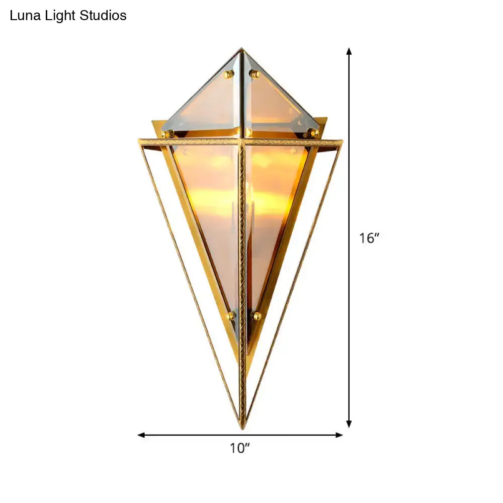 Modern gold geometric wall sconce with triangular amber glass panels emitting a warm glow for living room lighting