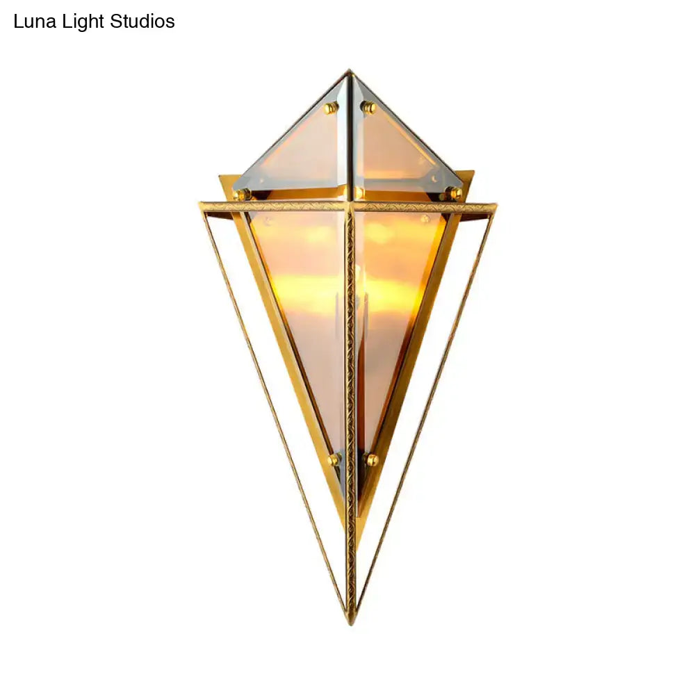 Modern gold geometric wall sconce featuring clear amber glass panels and a warm glow for living room lighting
