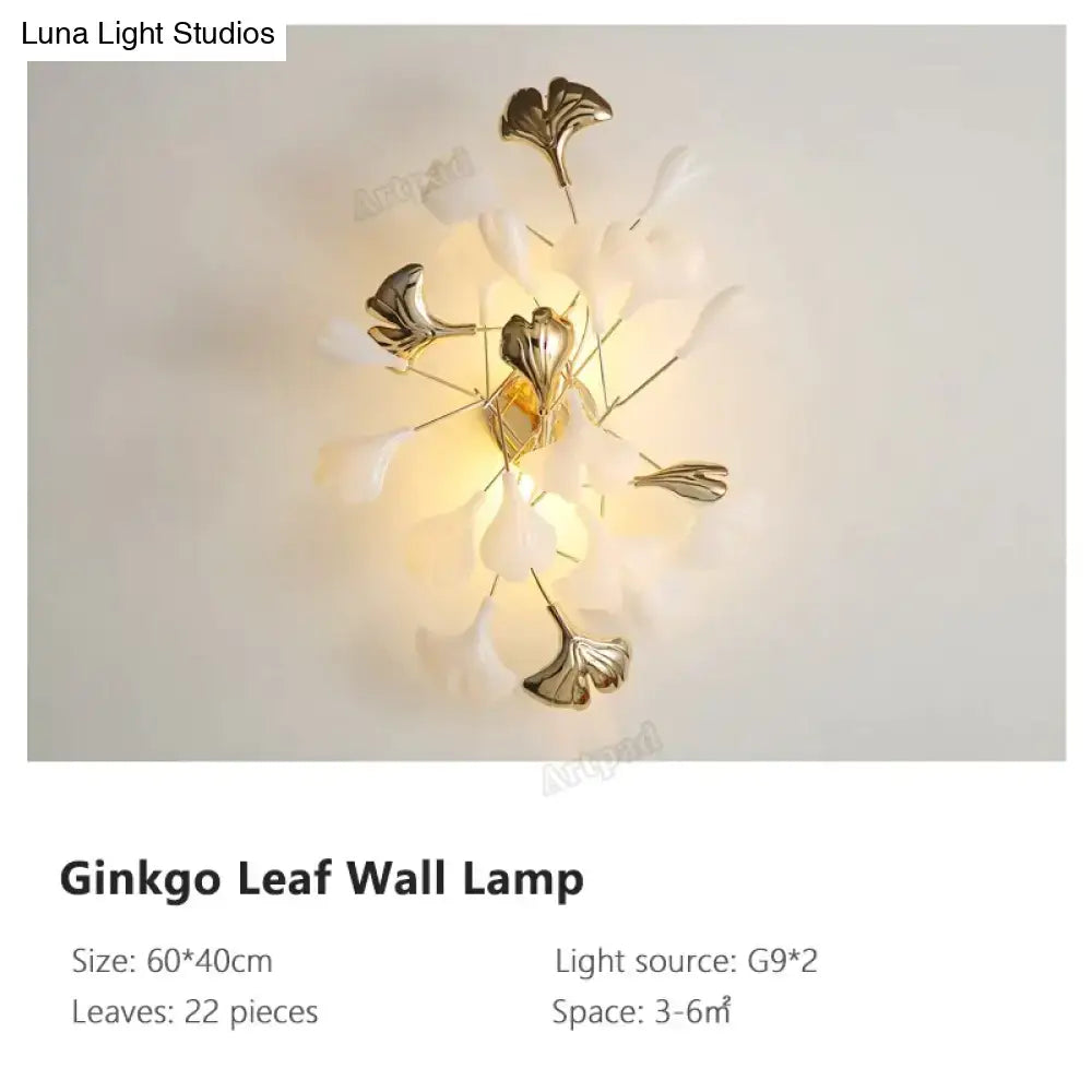 Modern gold ginkgo leaf porcelain wall sconce with translucent white petals and metallic gold leaves for bedrooms