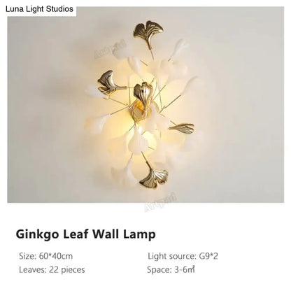 Modern gold ginkgo leaf porcelain wall sconce with translucent white petals and metallic gold leaves for bedrooms