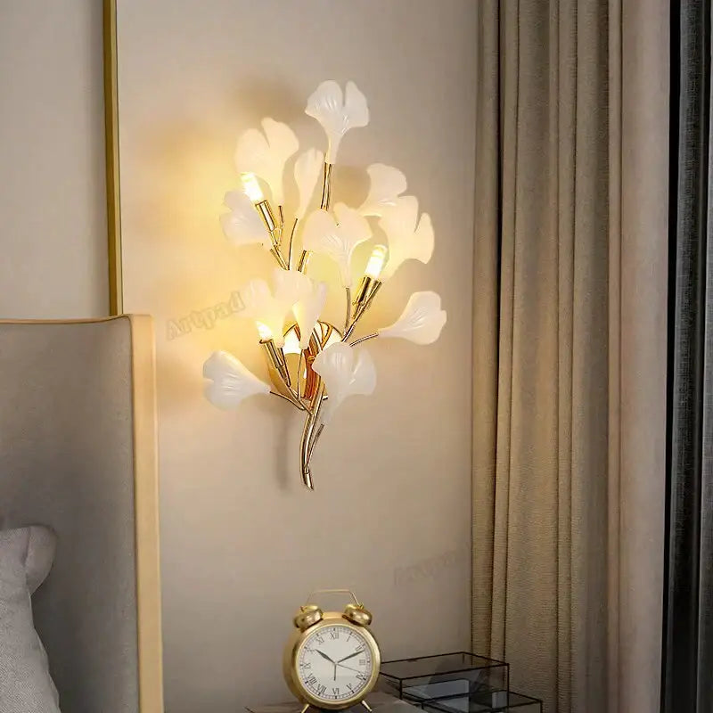 Modern gold ginkgo leaf porcelain wall sconce with elegant gold-toned frame and translucent white glass petals for bedroom lighting