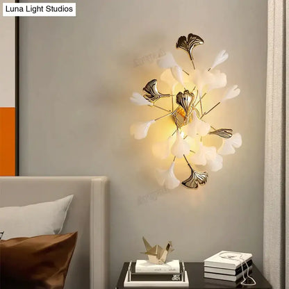 Elegant white and gold ginkgo leaf porcelain wall sconce with modern artistic design for bedroom lighting
