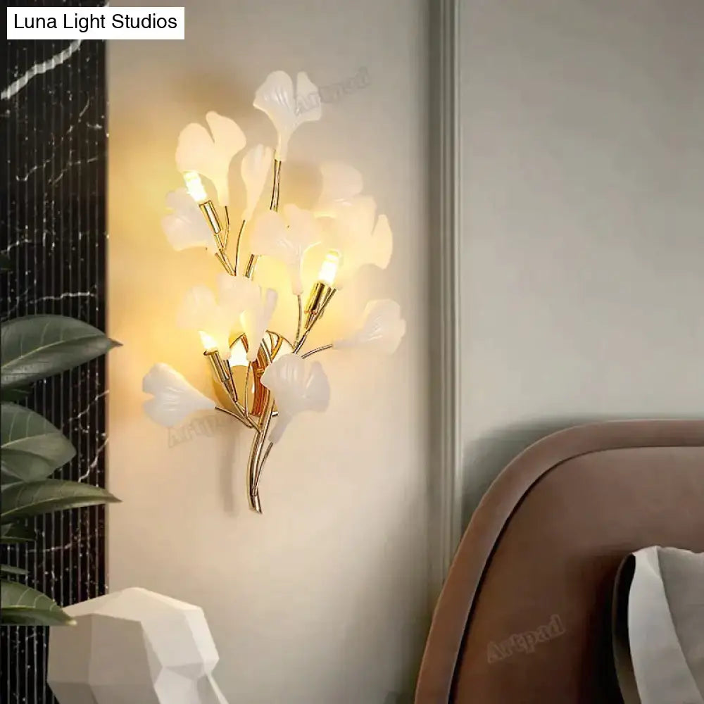 Modern gold ginkgo leaf porcelain wall sconce with elegant white leaves and gold-toned metal branches for bedroom lighting