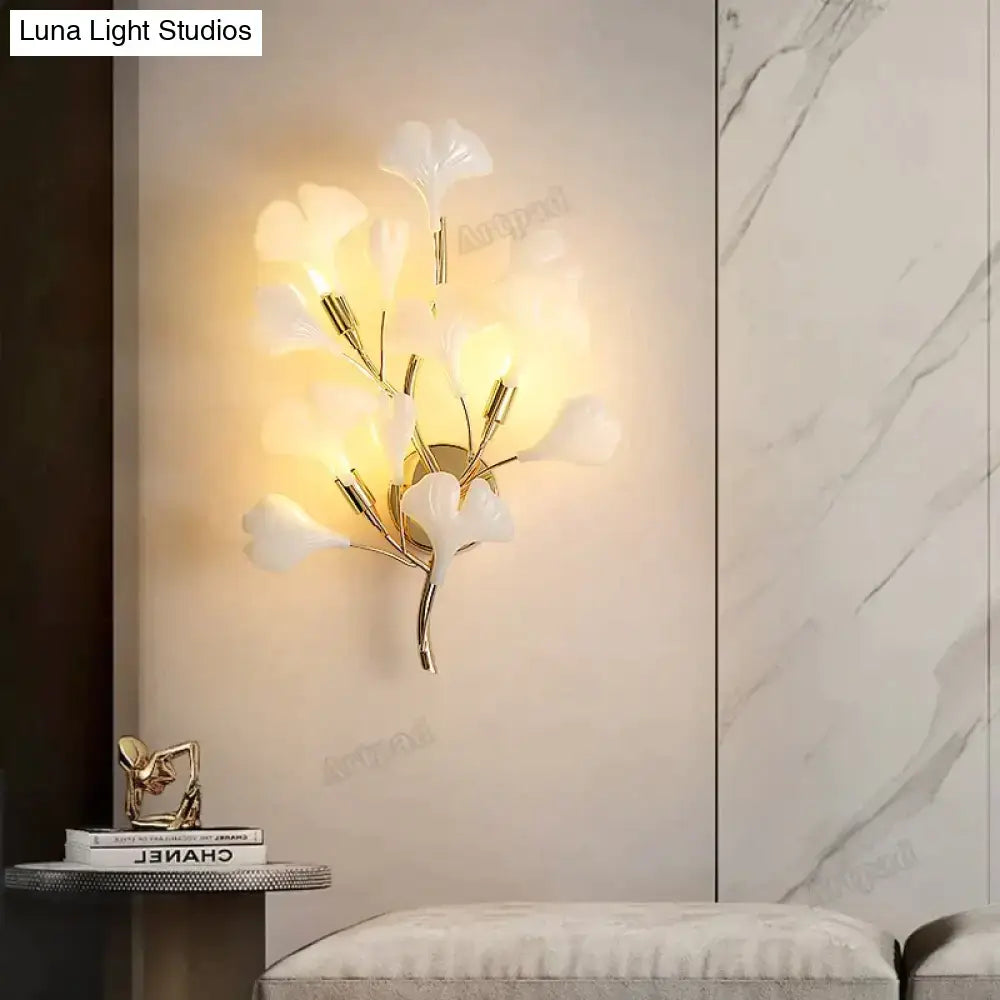 Elegant white porcelain ginkgo leaf wall sconce with gold-toned metal accents for modern bedroom lighting
