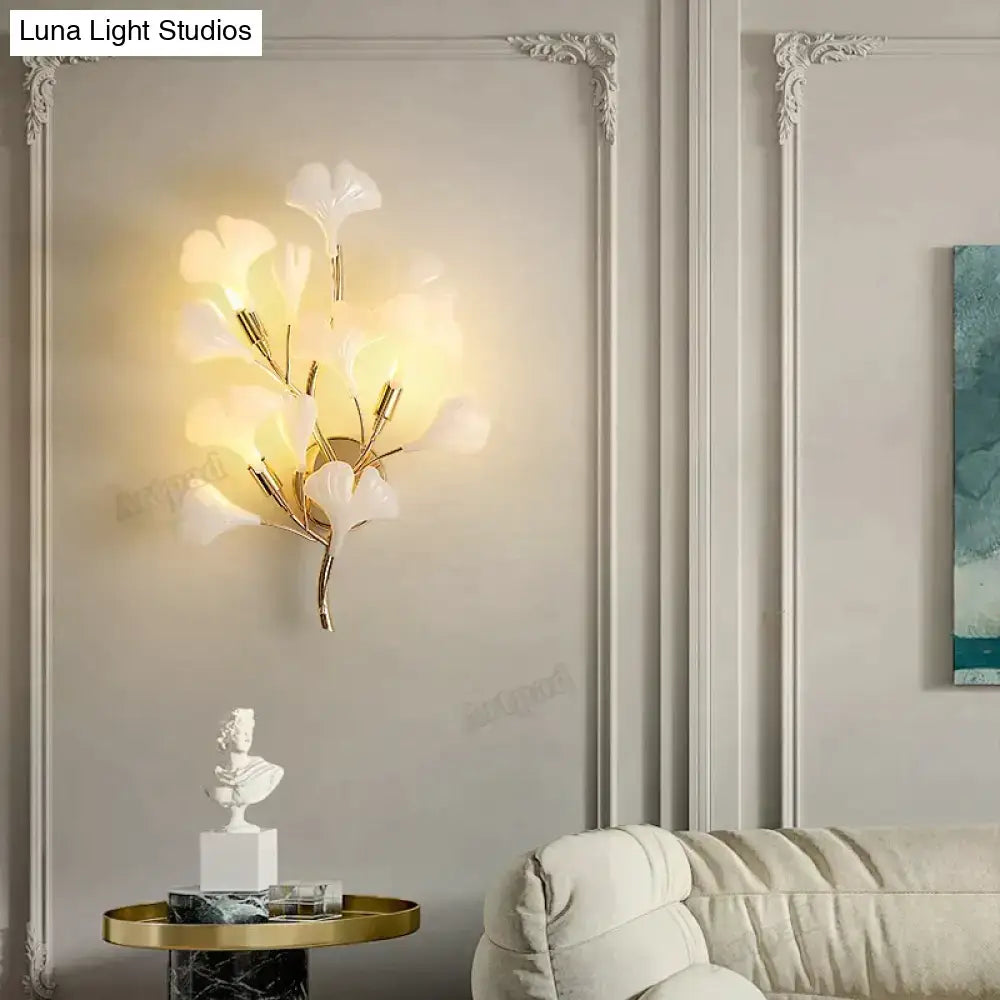 Elegant modern gold ginkgo leaf porcelain wall sconce with gold-toned branching design and translucent white glass shades