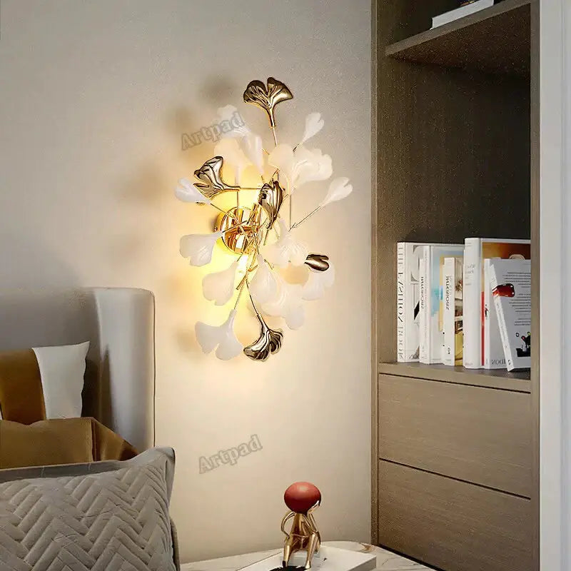 Modern gold ginkgo leaf porcelain wall sconce with delicate white and metallic leaf accents for bedroom lighting