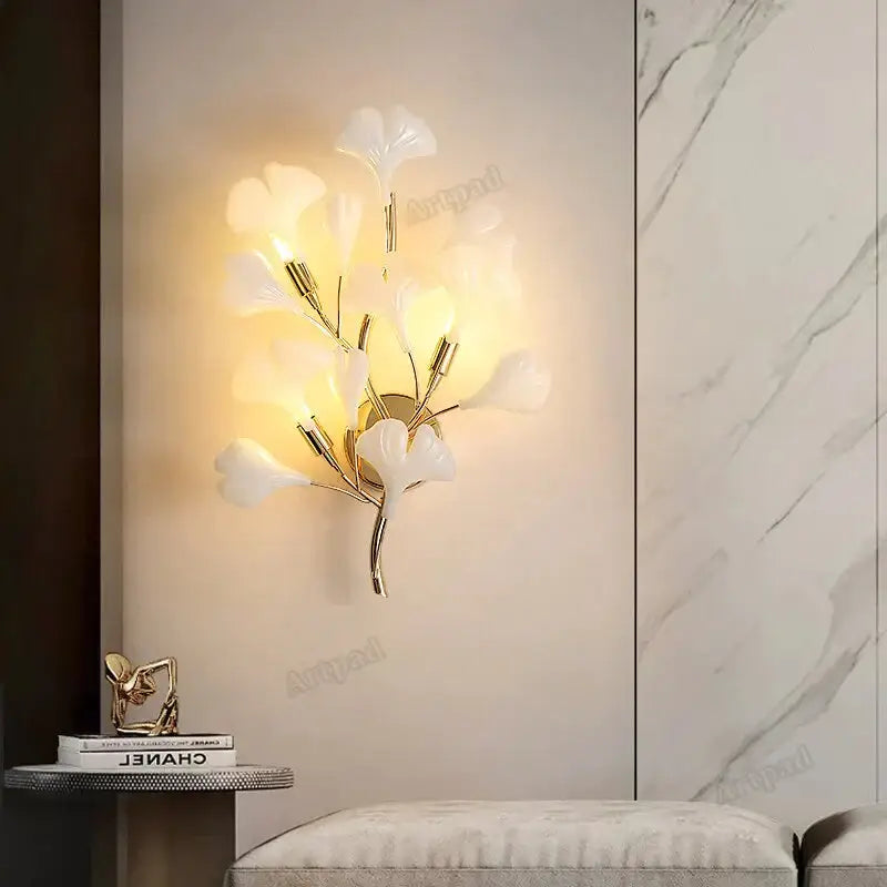 Modern gold ginkgo leaf porcelain wall sconce with gold-toned frame and translucent white leaf-shaped glass shades for bedroom use