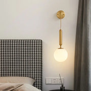 Modern gold glass ball led wall sconce with gold-toned cylindrical stem and frosted glass globe for bedroom decorbites decor