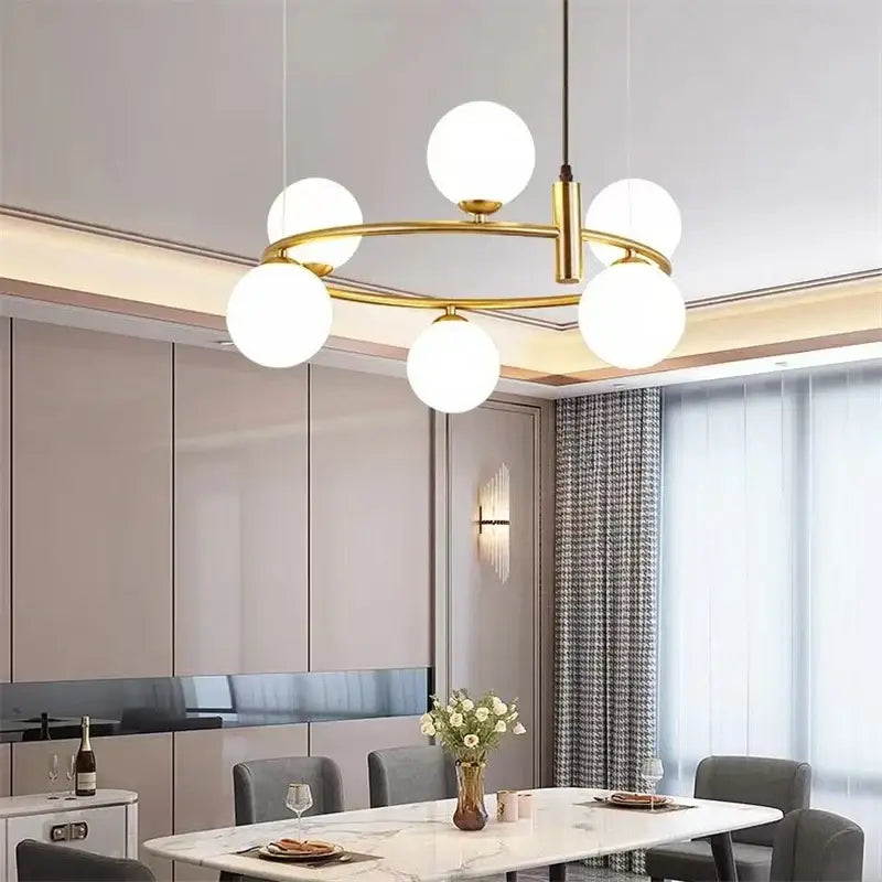 Modern gold glass ball pendant chandelier with five frosted glass globes arranged in a circular pattern for dining room decorbites glass ball