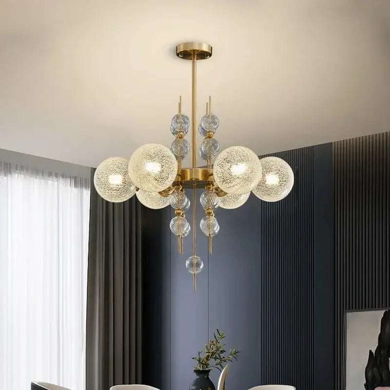 Modern gold glass ball pendant chandelier with clear textured spheres suspended from a central rod for kitchen island lighting decorbites glass ball