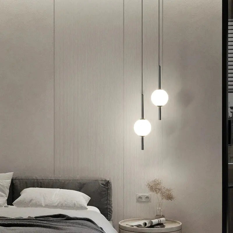 Modern gold glass ball pendant light with sleek black metal rods and glowing white spherical glass shades decorbites pendant light
