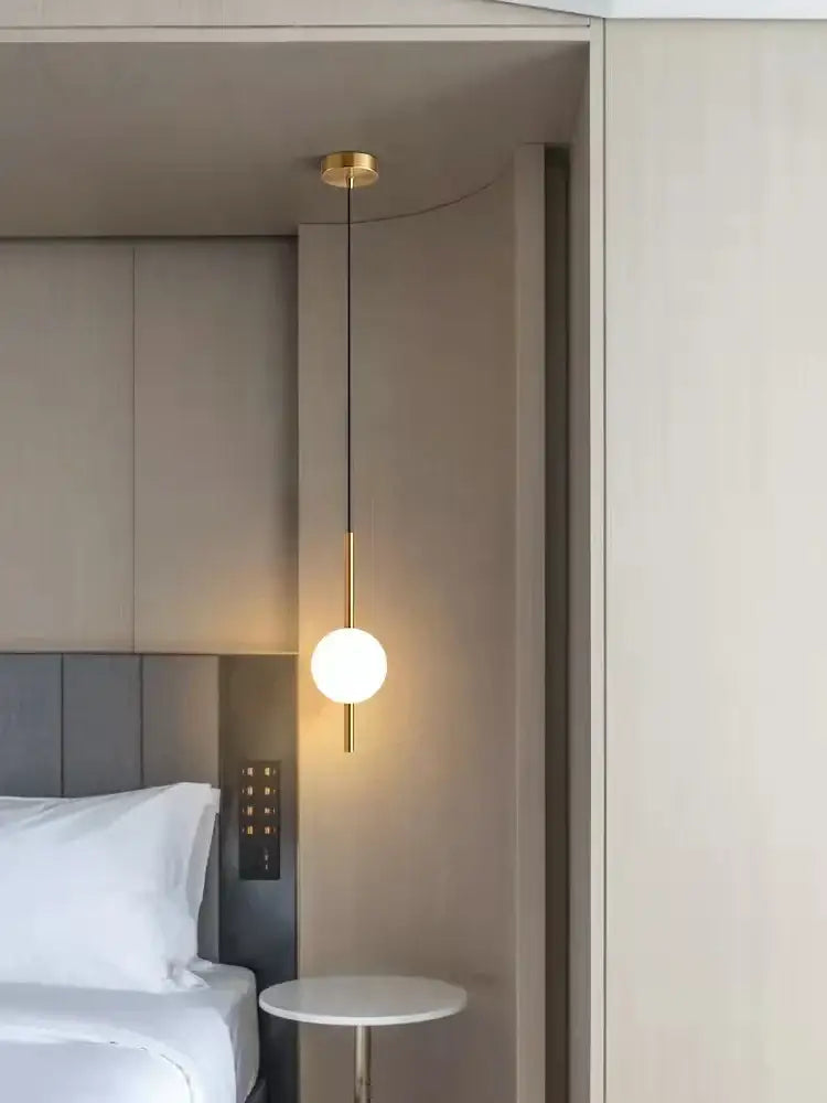 Modern gold glass ball pendant light featuring a frosted glass sphere suspended by a slender rod and chain decorbites glass ball