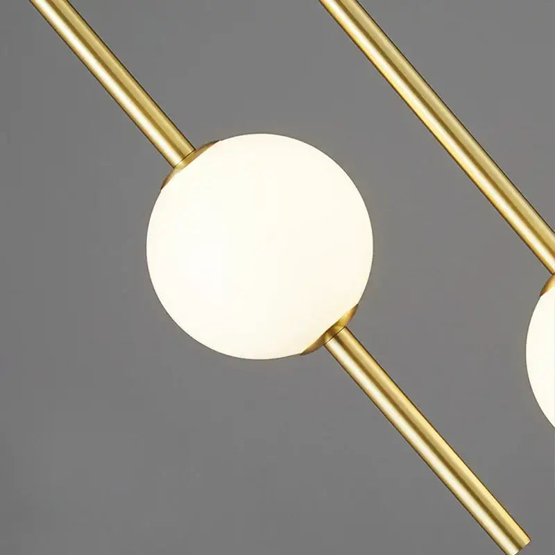 Modern gold glass ball pendant light featuring a spherical glass globe with intersecting brass rods for bedroom decorbites glass ball pendant light